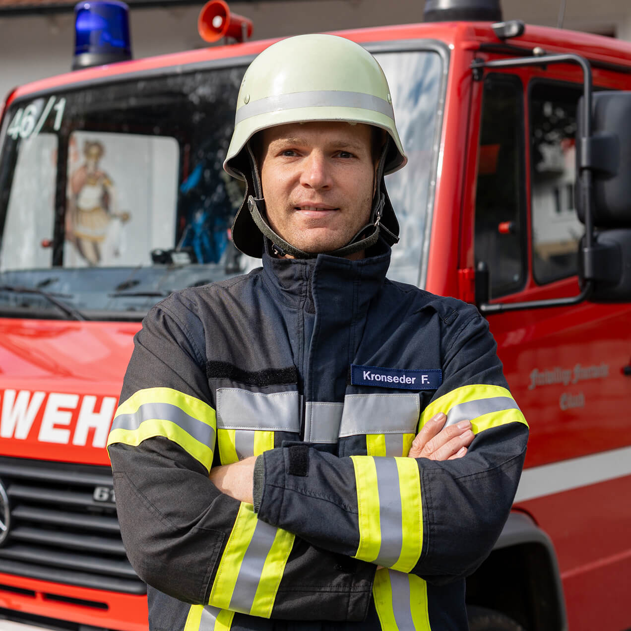 Feuerwehrmann in Schutzkleidung vor einem Feuerwehrfahrzeug